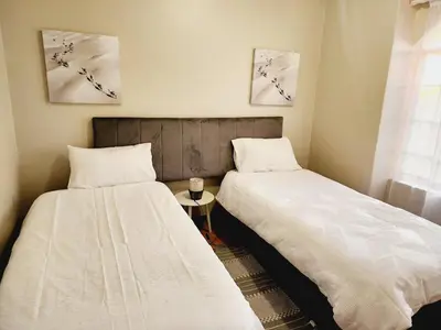 two beds sitting next to each other in a room at Sable woods in Pretoria