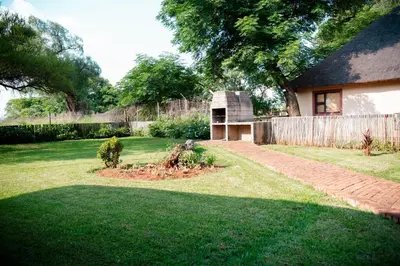 a yard with a house and a brick path at Falcon Lodge Bela Bela in Merinovlakte