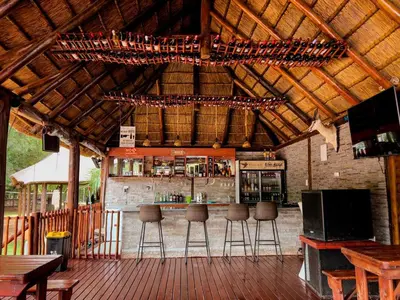 an outdoor bar with bar stools in a building at Falcon Lodge ET in Bela-Bela