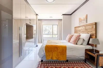 a bedroom with a bed and a large window at Walford Estate, Spacious Private, Modern luxury living in Midrand