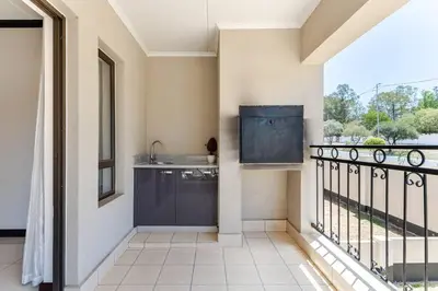 a kitchen with a sink and a balcony at Walford Estate, Spacious Private, Modern luxury living in Midrand