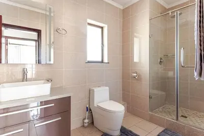 a bathroom with a toilet and a sink and a shower at Walford Estate, Spacious Private, Modern luxury living in Midrand