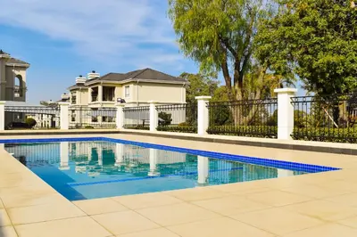 a swimming pool in front of a house at Walford Estate, Spacious Private, Modern luxury living in Midrand