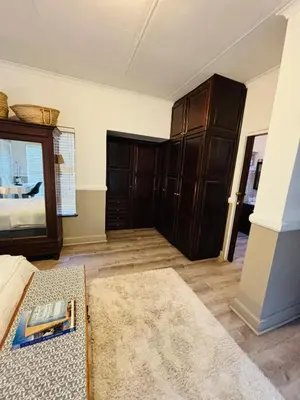 a living room with a bed and a mirror at Spacious Room in Pretoria East in Pretoria