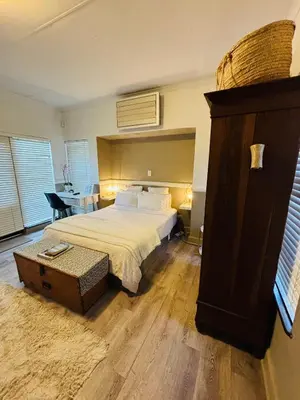 a bedroom with a bed and a dresser in it at Spacious Room in Pretoria East in Pretoria