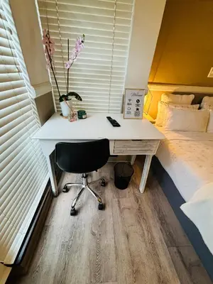 a desk with a chair next to a bed at Spacious Room in Pretoria East in Pretoria