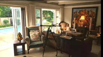 a living room with a couch and a camera at The Giraffe Room at Frederick's Place in Pretoria
