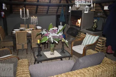 a living room with a table with a vase of flowers at The Giraffe Room at Frederick's Place in Pretoria