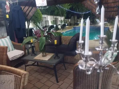 a table with candles on it next to a pool at The Giraffe Room at Frederick's Place in Pretoria