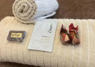 a packet of chocolates and a bar of chocolate on a towel at The Giraffe Room at Frederick's Place in Pretoria