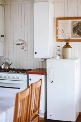 a kitchen with a stove and a white refrigerator at Die Boothuis at Lake Chrissie in Lake Chrissie
