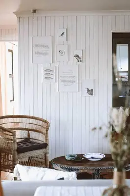 a room with a table and chairs and a wall with pictures at Die Boothuis at Lake Chrissie in Lake Chrissie
