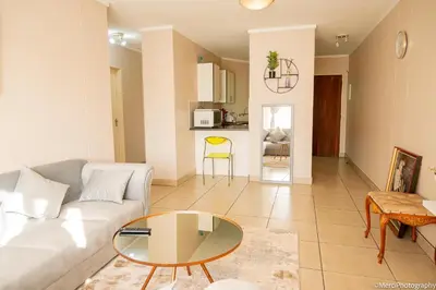 a living room with a couch and a table at Premium Getaway at Menlyn Maine in Pretoria
