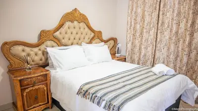 a bedroom with a large bed and a wooden nightstand at Premium Getaway at Menlyn Maine in Pretoria