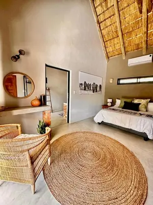 a bedroom with a bed and a large rug at Pumba Lodge Hoedspruit in Hoedspruit