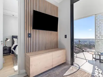 a living room with a tv on a wall at Ellipse Waterfall 3909 in Midrand