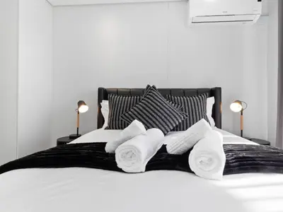 a white bed with three rolled towels on it at Ellipse Waterfall 3909 in Midrand