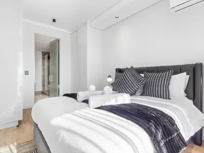 a white bedroom with a large bed with pillows at Ellipse Waterfall 3909 in Midrand