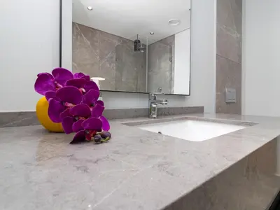 a bathroom with a sink and a purple flower on a counter at Ellipse Waterfall 3909 in Midrand