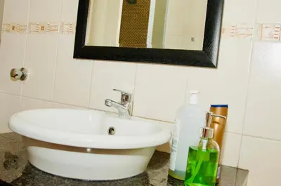 a bathroom with a sink and a mirror at Palm Haven 5 min drive to Carlswald Centre in Midrand