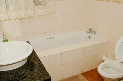 a bathroom with a white tub and a toilet at Palm Haven 5 min drive to Carlswald Centre in Midrand