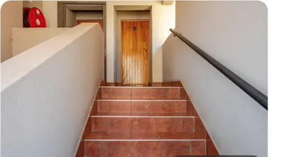 a stairway with a wooden door and a stair case at Palm Haven 5 min drive to Carlswald Centre in Midrand