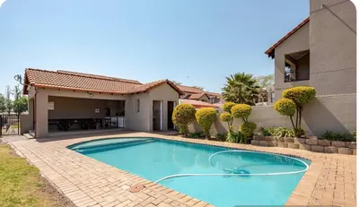 a swimming pool in front of a house at Palm Haven 5 min drive to Carlswald Centre in Midrand
