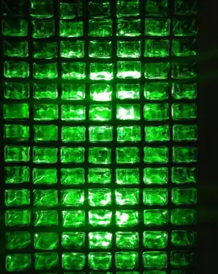 a green tile wall with green lights on it at The Eco Hut in Hoedspruit