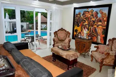 a living room with a large painting on the wall at The Presidential Suite at Frederick's Place in Pretoria
