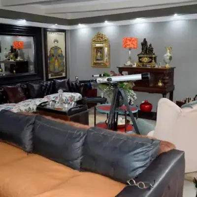 a living room with a black leather couch at The Presidential Suite at Frederick's Place in Pretoria