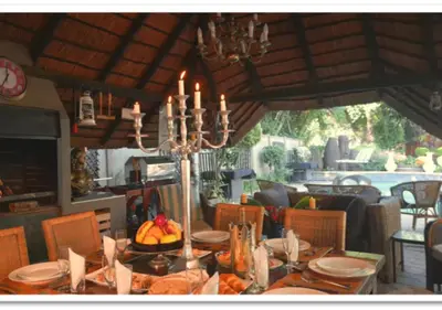 a dining room with a table with a chandelier at The Presidential Suite at Frederick's Place in Pretoria