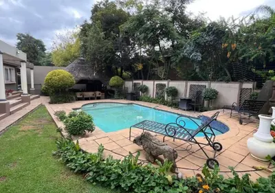 a swimming pool with a statue of a dog in a yard at The Presidential Suite at Frederick's Place in Pretoria