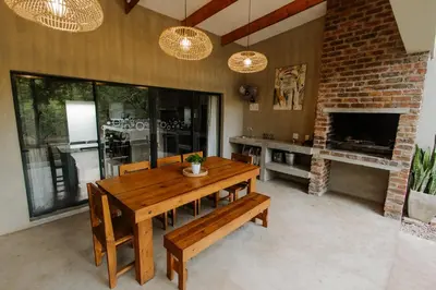 a living room with a wooden table and a fireplace at Afri Villa Stays - Luxury Bush Villa Bird in Marloth Park