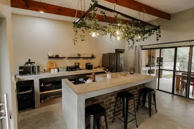 a kitchen with a large island with bar stools at Afri Villa Stays - Luxury Bush Villa Bird in Marloth Park