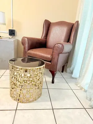 a living room with a chair and a coffee table at Whizzy Lifestyle Lodge in Witbank