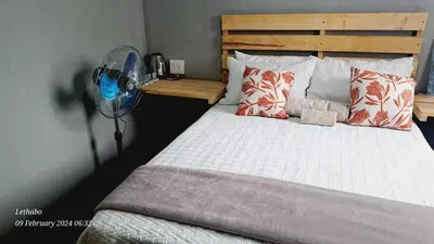 a bedroom with a bed with a fan and pillows at Matibidi Guest Lodge in Graskop