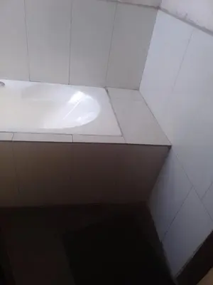 a white bathroom with a white shelf in a room at Matibidi Guest Lodge in Graskop