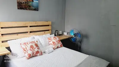 a bedroom with a bed with a fan and pillows at Matibidi Guest Lodge in Graskop