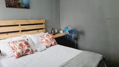a bedroom with a bed with a fan and pillows at Matibidi Guest Lodge in Graskop