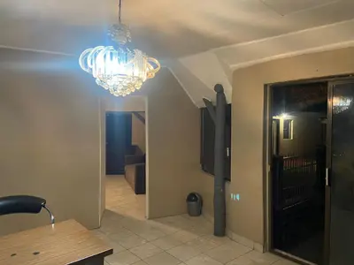 a chandelier hanging over a hallway with a room at Eccoo OR Tambo Airport lodge in Kempton Park