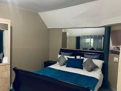 a bedroom with a bed with blue and white pillows at Eccoo OR Tambo Airport lodge in Kempton Park