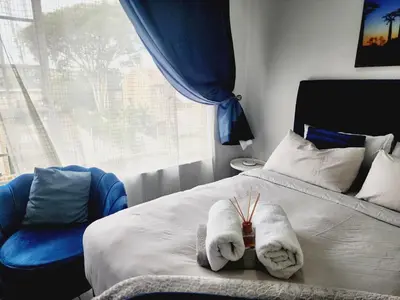 a bedroom with towels on a bed with a window at Olympus Side in Pretoria