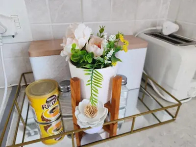 a white vase filled with flowers on a shelf at Olympus Side in Pretoria