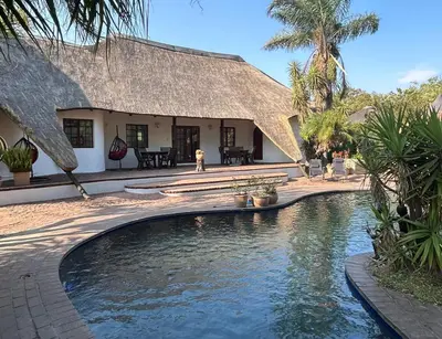 a house with a swimming pool in front of a building at Wood Valley in Midrand