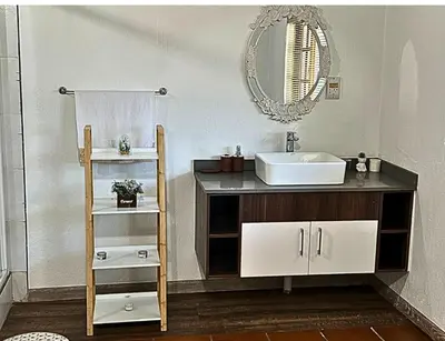 a bathroom with a sink and a mirror at Wood Valley in Midrand