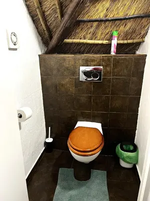 a bathroom with a toilet with a wooden toilet seat at Wood Valley in Midrand