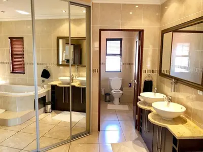 a large bathroom with two sinks and two toilets at Villa on 8 Pecanwood in Hartbeespoort