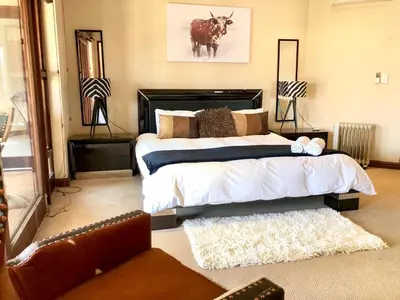 a bedroom with a large bed in a room at Villa on 8 Pecanwood in Hartbeespoort