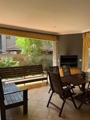 a patio with a table and chairs and a bench at Villa on 8 Pecanwood in Hartbeespoort