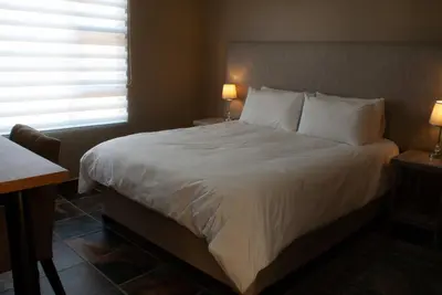 a bedroom with a large bed with white sheets and pillows at Casa de la Presa 1 in Polokwane